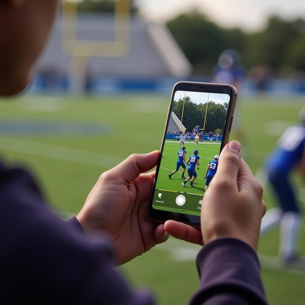 A fan watching Gladbrook Reinbeck football live stream on their phone